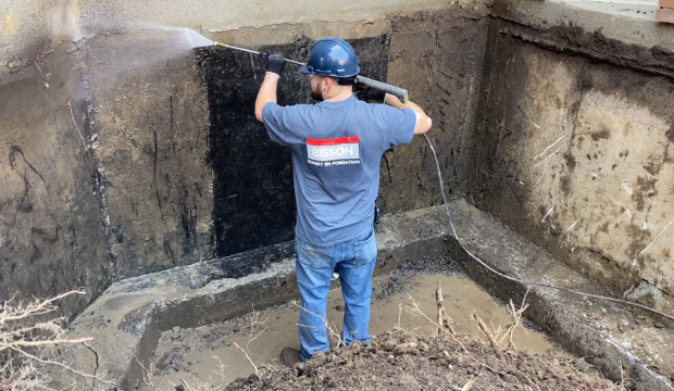 Foundation Waterproofing - Cleaning the foundation for better membrane adhesion.